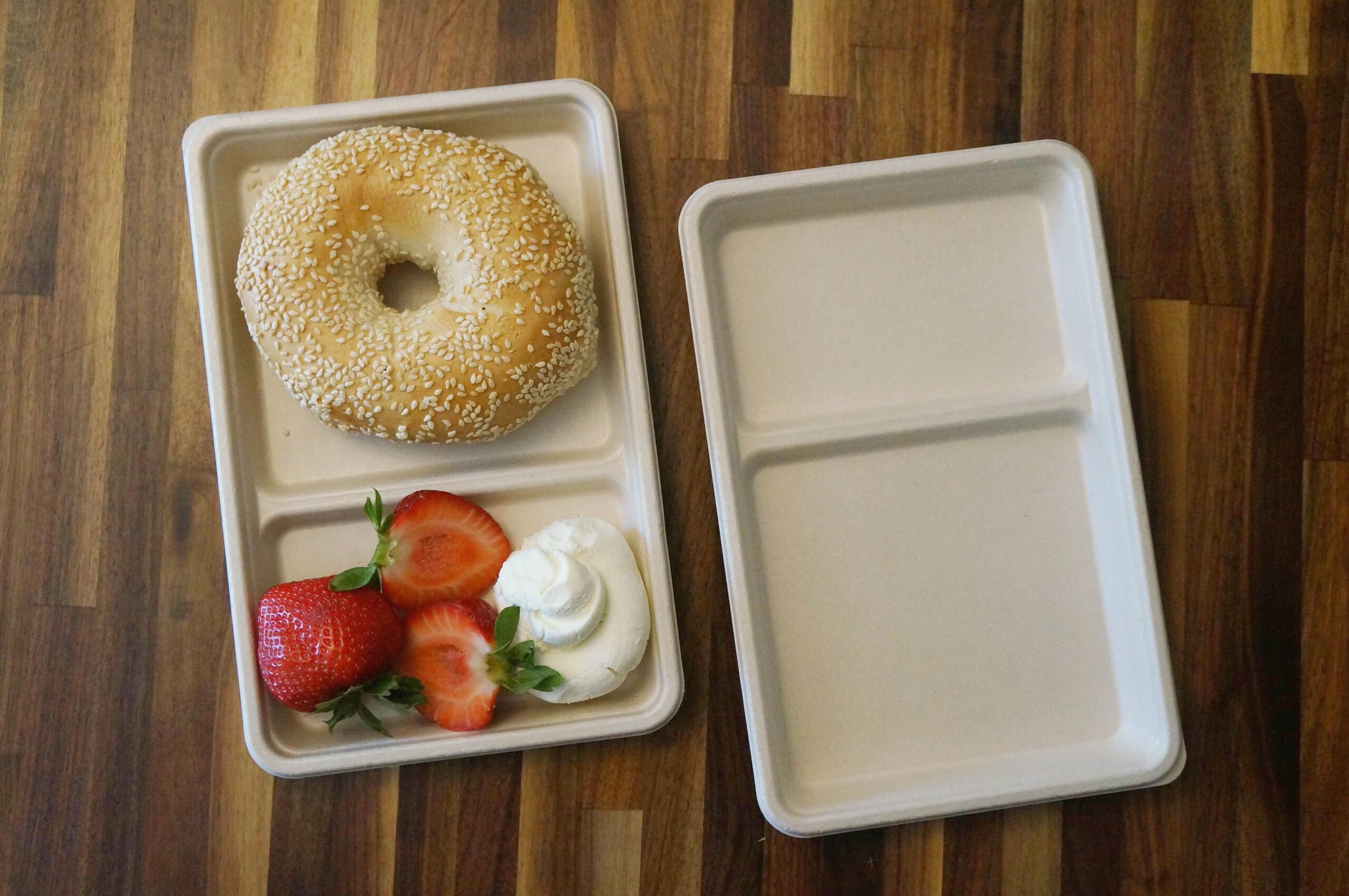 top view of food tray with bagel and straberries