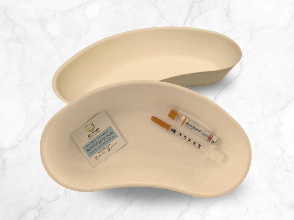 top view of kidney shaped medical tray with syringes